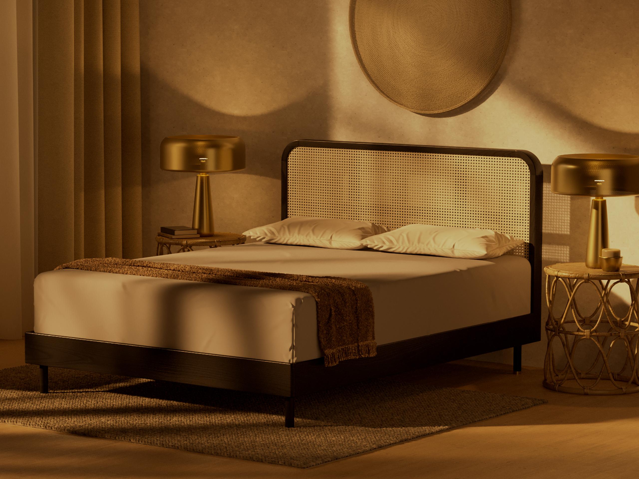 A bed in the centre of a light-filled and neutral tone bedroom, with plants on the windowsill.
