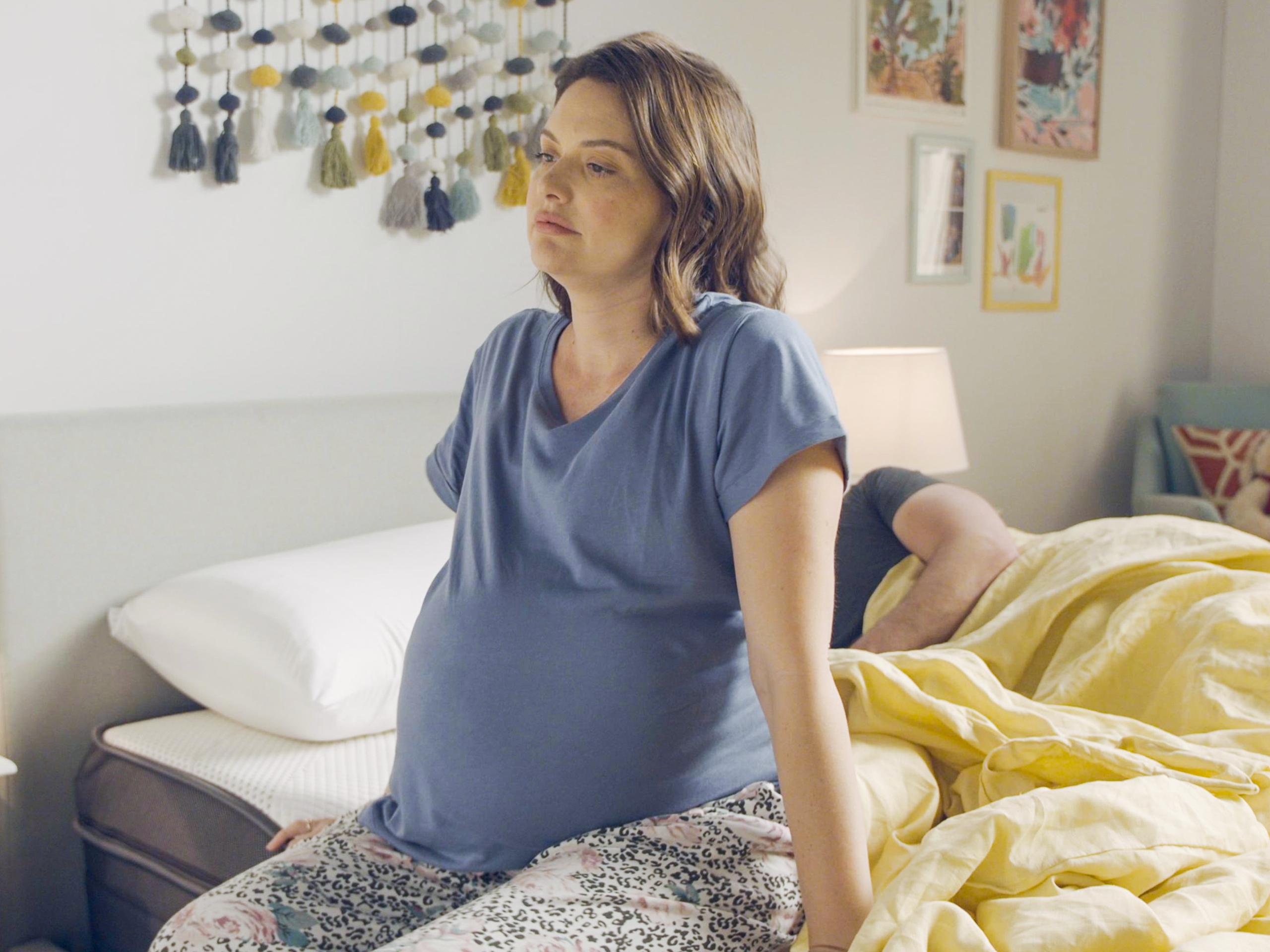 Image of pregnant woman sitting on bed